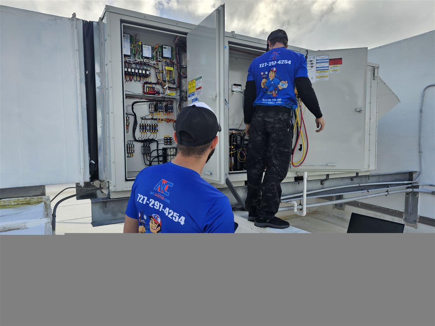 ACDR technicians inspecting rooftop unit control panel